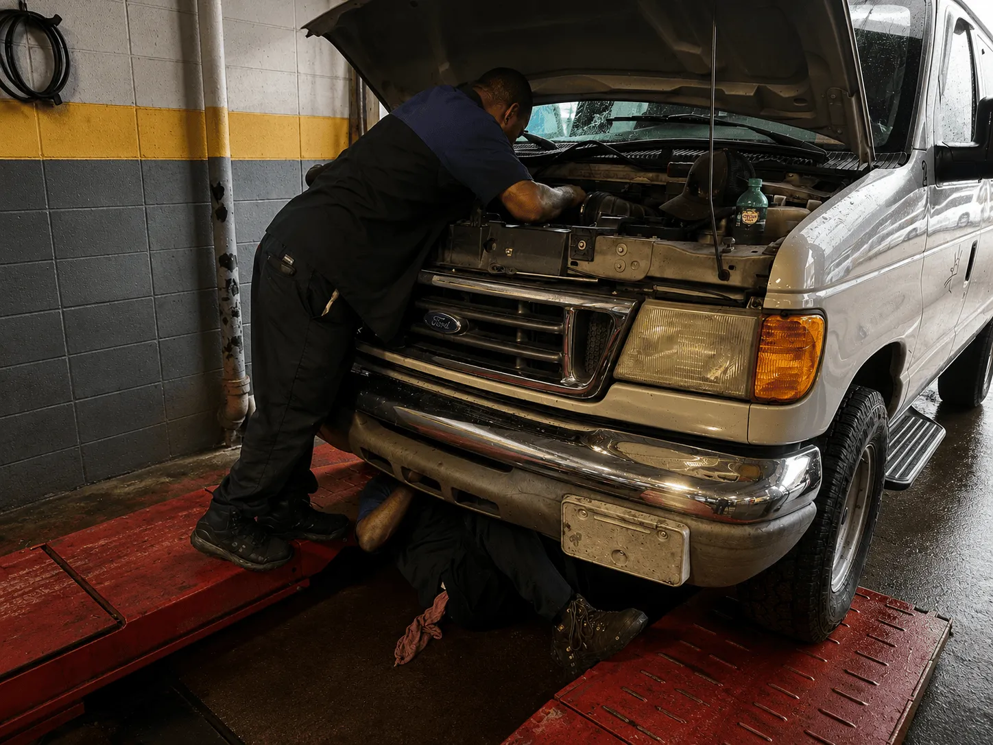 Technicians working on a vehicle at Thomas Tire in Pearl, MS